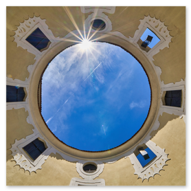 ufwärts gerichtete Aufnahme im Eingangs­bereich von Schloss Lamberg mit ovaler Deckenöffnung, durch die der blaue Himmel und die Sonne als strahlen­förmiger Leuchtpunkt sichtbar sind. Rund um die Öffnung reihen sich symmetrisch angeordnete Fenster mit dekorativen Sandstein­einrahmungen. Ideal für SEO-Stichworte wie Schloss Lamberg, Zugangsbereich, Deckenöffnung, historische Architektur, Aufsicht und Mühlviertel.