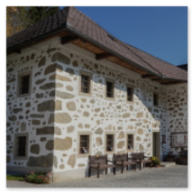 Steinbloßhaus mit Holzgiebel und Bänken am Hi 10 Weg in Hirschbach