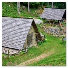 Historische Baustelle in Friesach mit Holzhütten, Steinmauern und mittelalterlichem Handwerk inmitten grüner Natur