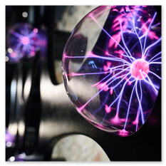 Mehrere Plasmakugeln mit leuchtenden Entladungen auf dunkler Fläche, Teil der künstlerischen Installation von André Heller im Weingut Taggenbrunn