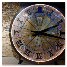 Künstlerisch gestaltete Uhr mit römischen Ziffern und Mosaikstruktur in Gold und Silber, montiert auf Steinwand, Teil der André-Heller-Ausstellung im Weingut Taggenbrunn