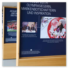 Holztafel mit Text und Bildern zur Olympiasiegerin Anna Veith, Teil der Ausstellungsreihe im Weingut Taggenbrunn