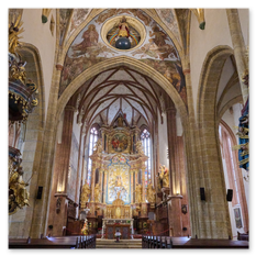 Gotischer Innenraum mit goldverziertem Altar, Fresken und Rippengewölbe bei Maria Saal – Engelreliefs, dunkle Kuppel und Bankreihen in feierlicher Raumordnung.
