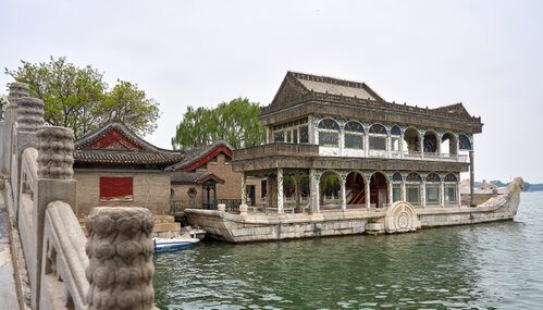 Steinpavillon in Bootsform am Kunming-See, zweistöckige Struktur mit verzierten Fenstern und traditionellen Dächern, ruhige Wasserfläche mit Spiegelung, umgeben von Brücken und historischen Gebäuden
