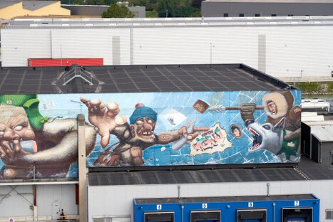 Das großformatige Graffito verwandelt die Industriehalle in eine Bühne voller Bewegung und Fantasie. Trotz der dynamischen Szene entsteht ein stiller Betrachtungsraum: Wer hier liegt oder verweilt, kann sich dem Erzählen überlassen—zwischen fliegenden Büchern, Masken und Figuren, die wie Gedanken durch die Wand treiben.